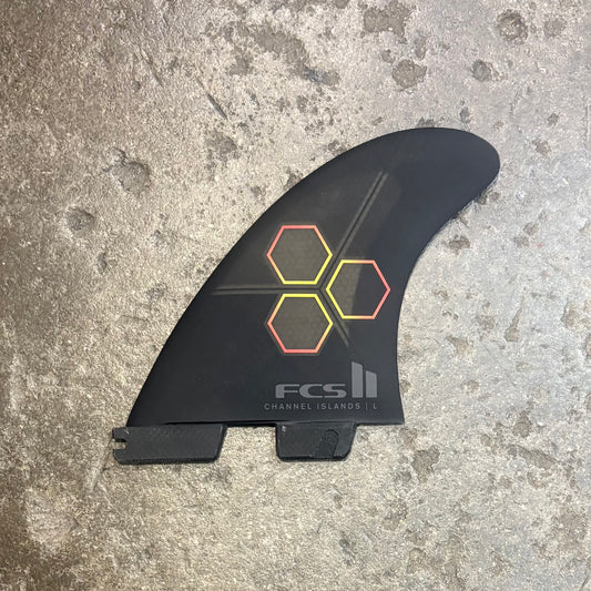 Black surf fin with colorful hexagonal design on a textured surface
