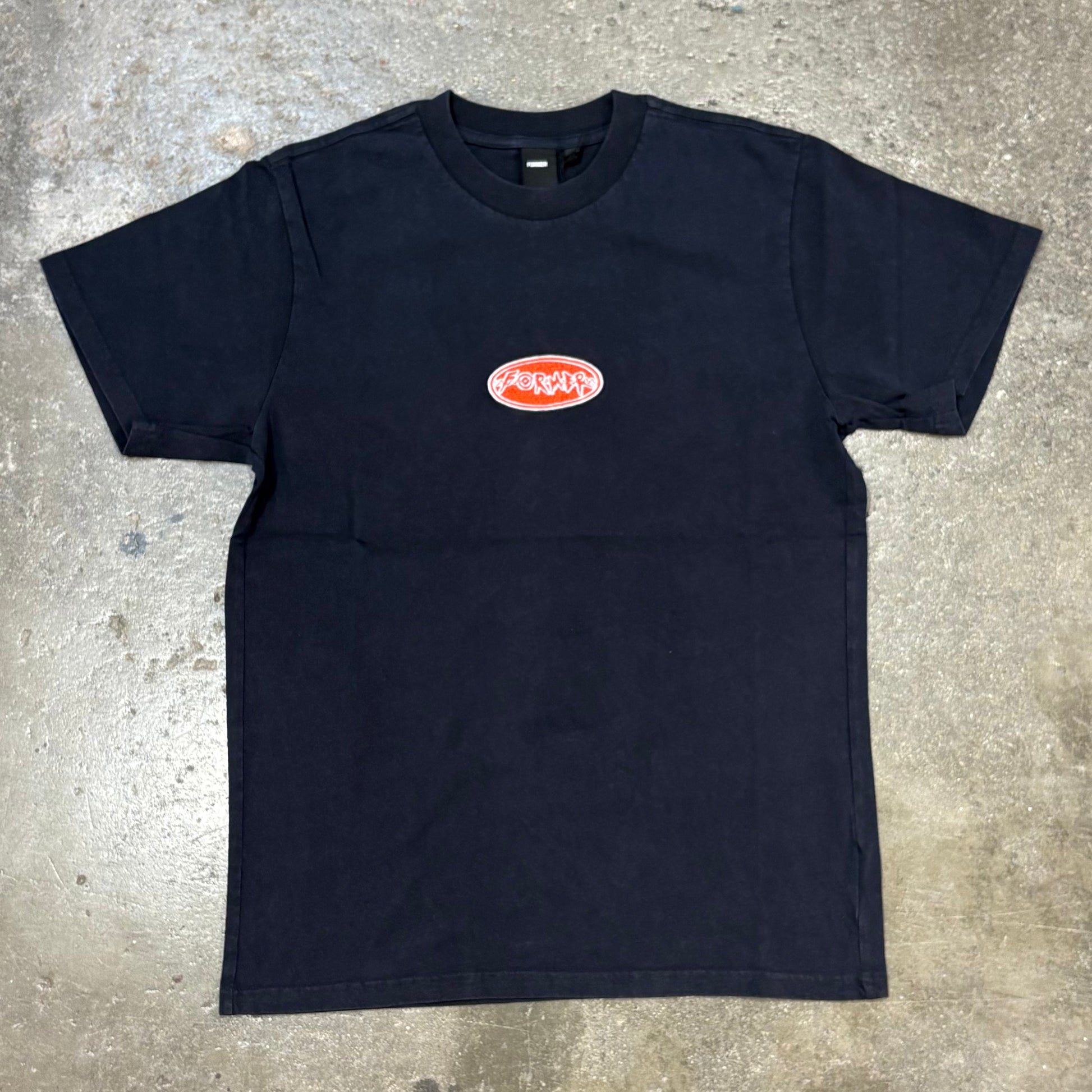 Black t-shirt with a logo on a concrete surface