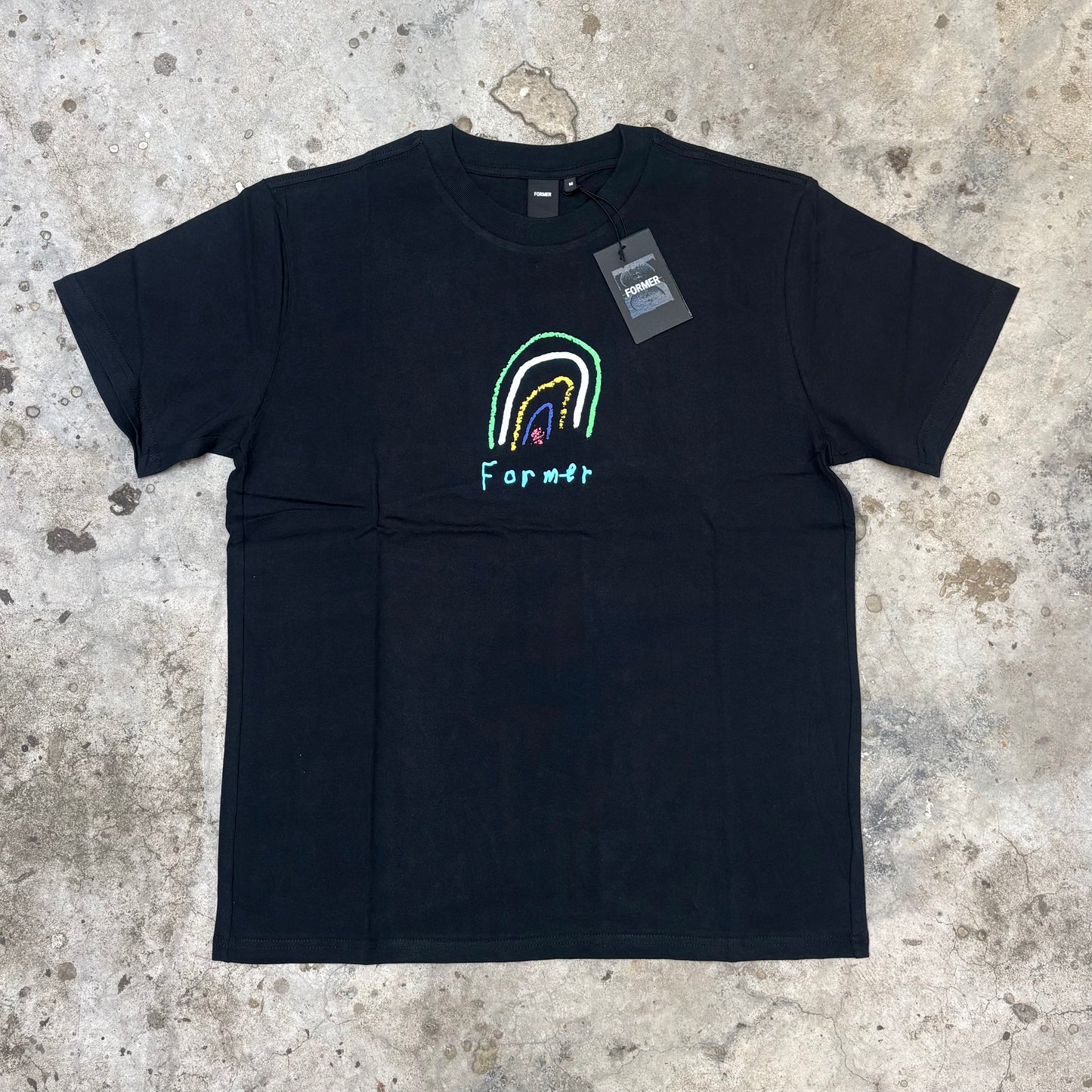 Black t-shirt with a colorful rainbow design and 'Famous' branding on a textured surface