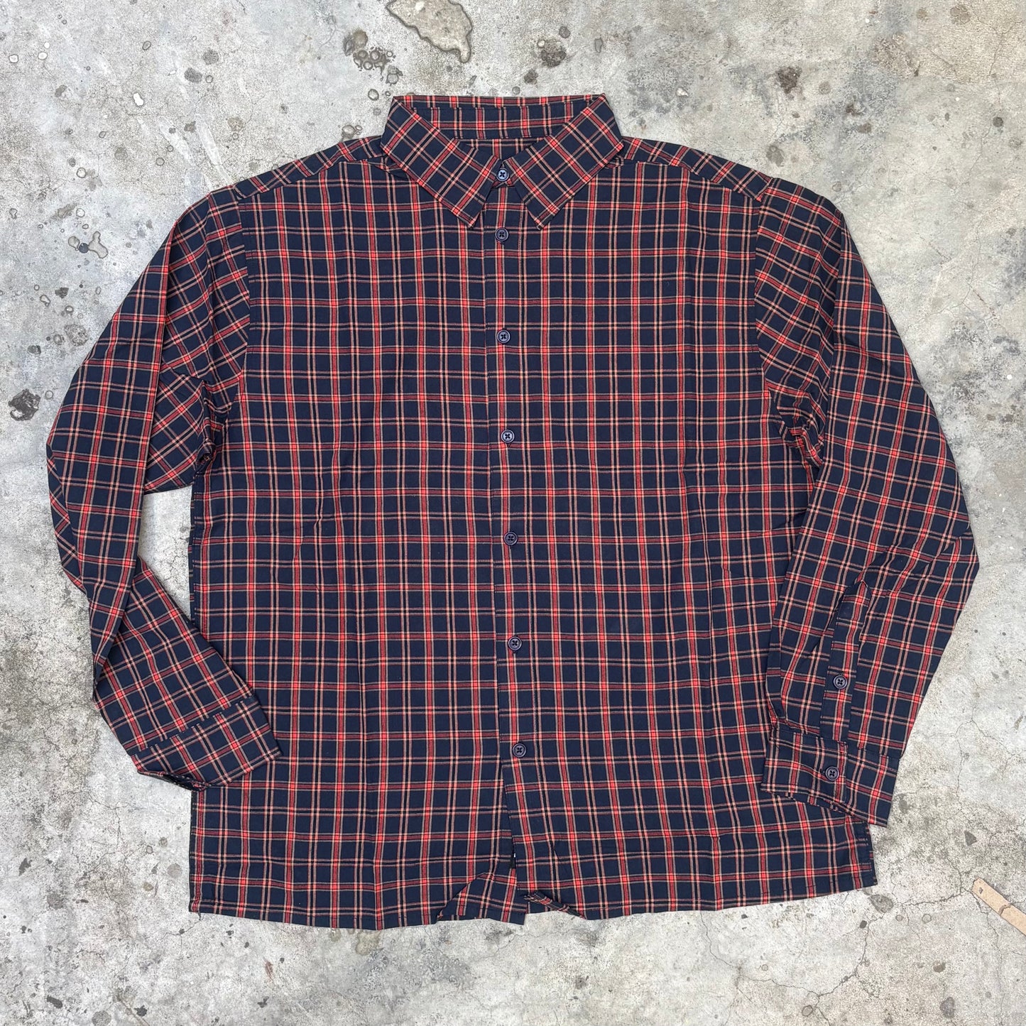 Red and blue plaid shirt on a concrete surface