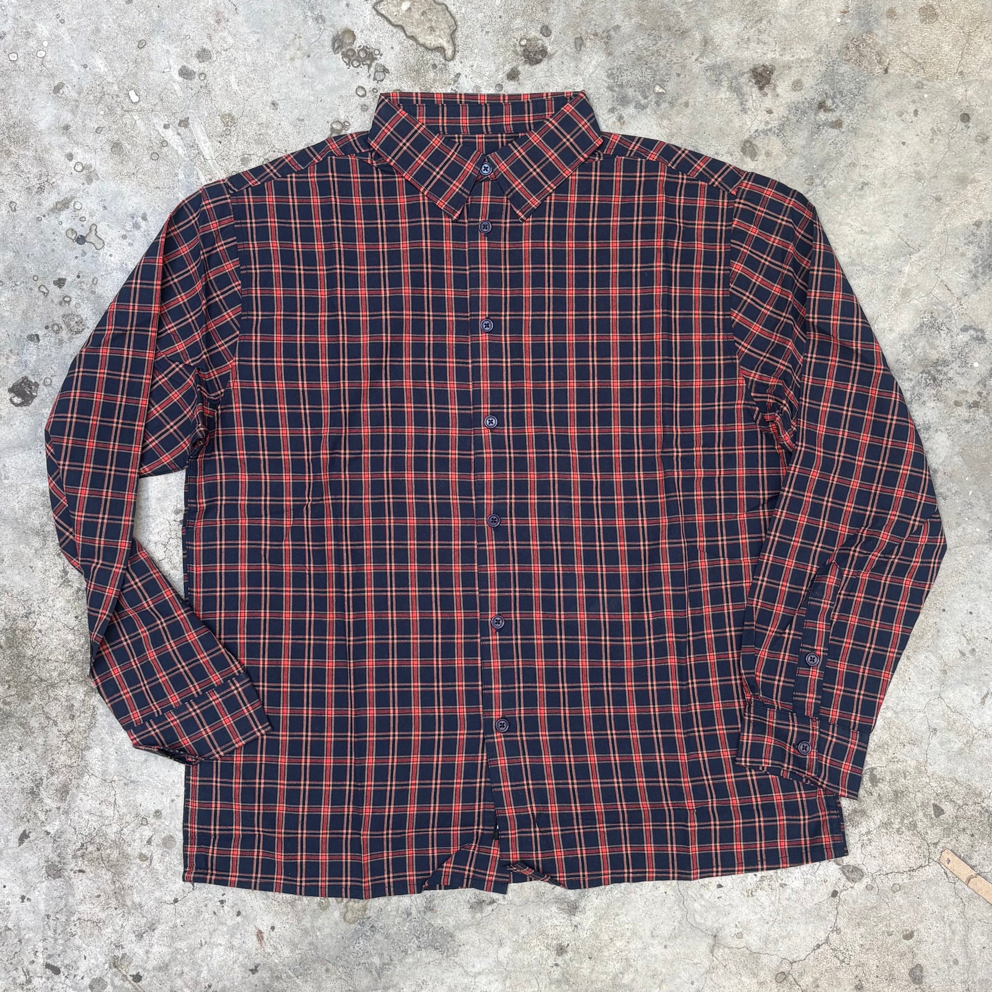 Red and blue plaid shirt on a concrete surface
