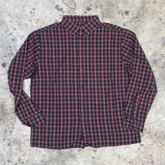 Red and blue plaid shirt on a concrete surface