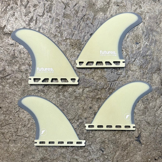 Four futures EA Control Series Quad surfboard fins with 'futures' branding on a textured surface