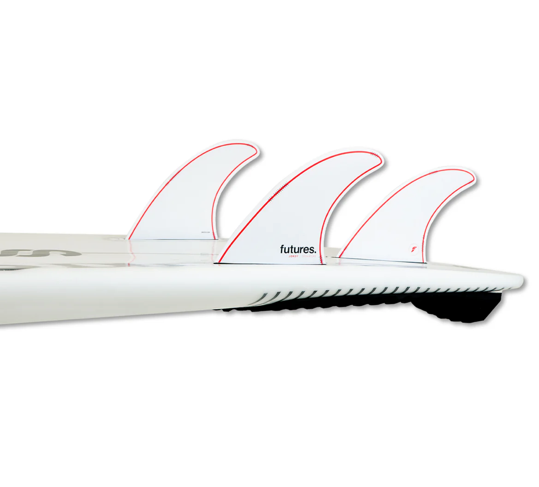 Close-up of a surfboard with a set of Jordy Smith signature fins on a white background.