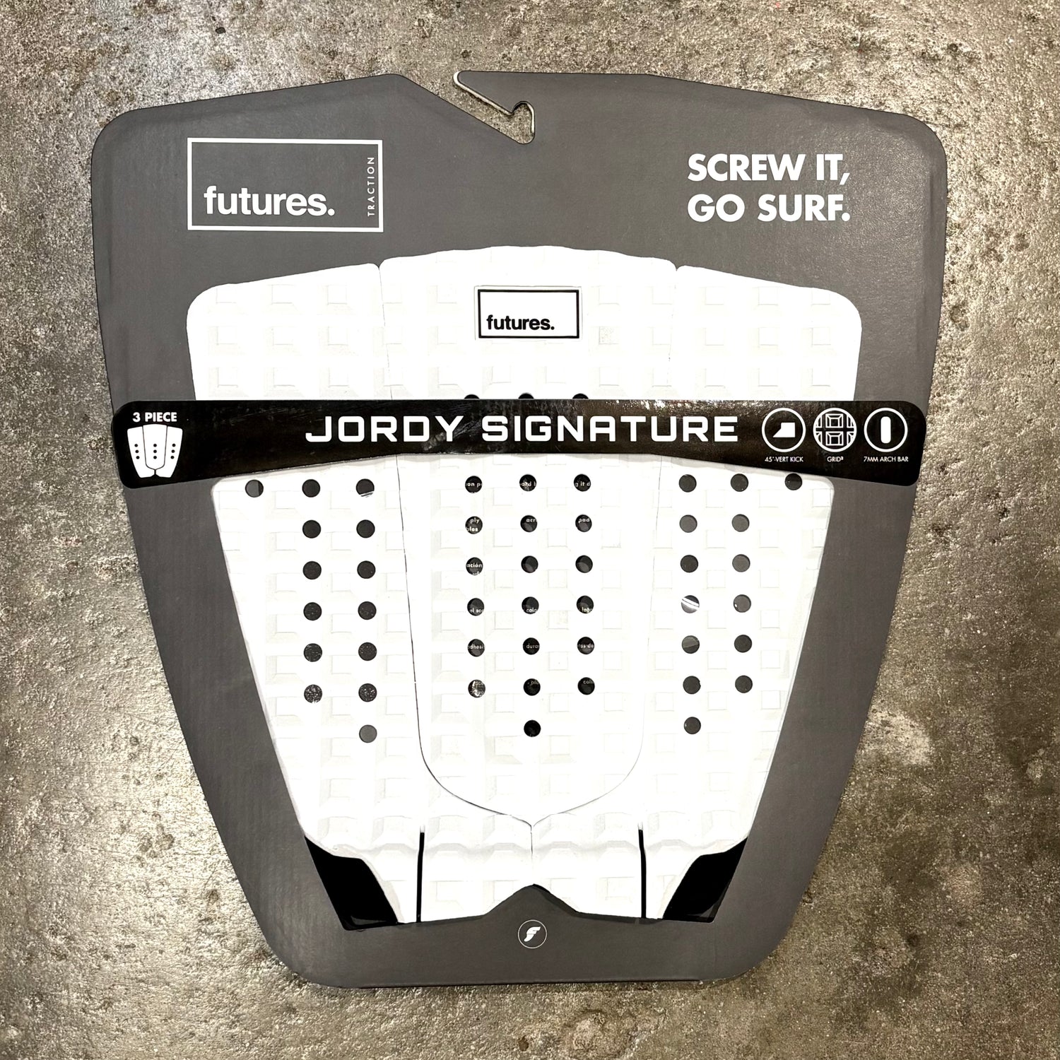 Jordy Smith signature surfboard tail pad in a white and black colour way on a textured surface.