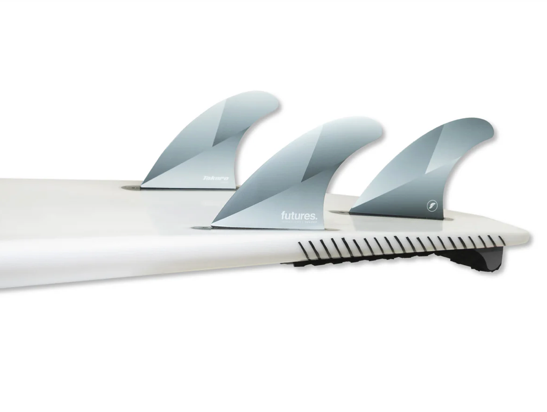 A set of Futures Tokoro silver surfboard fins in a silver colour way in a surfboard, against a white background.