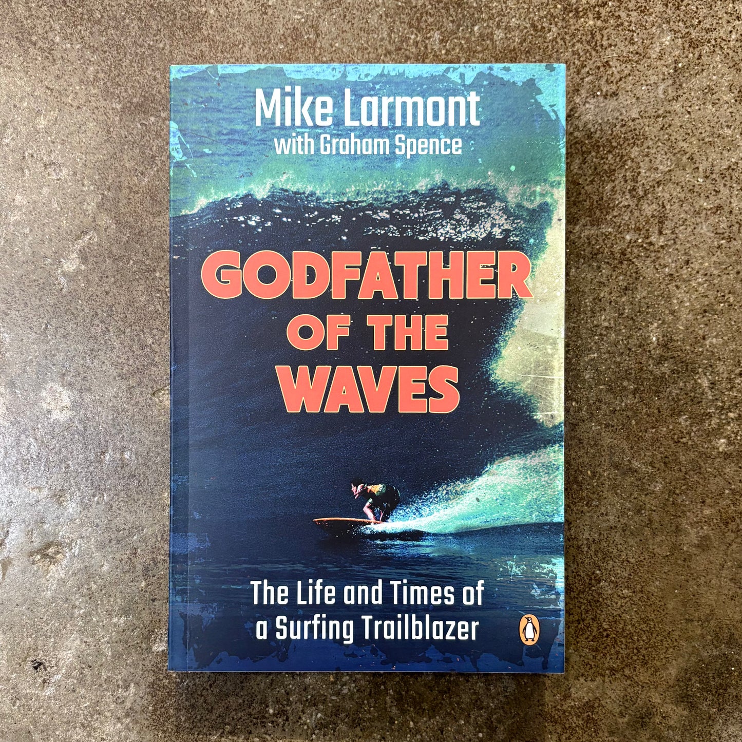 Book cover of 'Godfather of the Waves' by Mike Larment with Grahame Spence on a textured surface.
