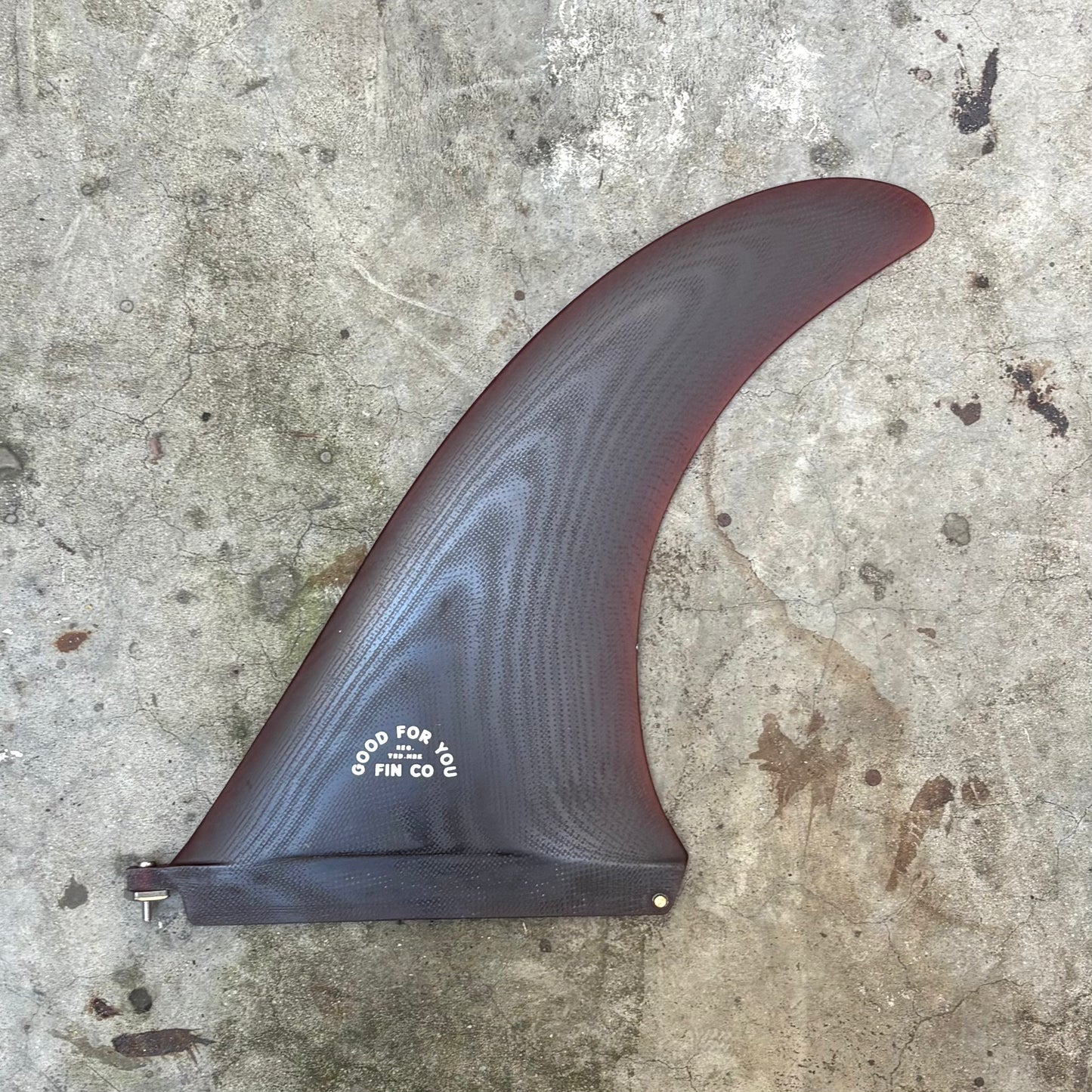 Surfboard fin on a textured concrete surface
