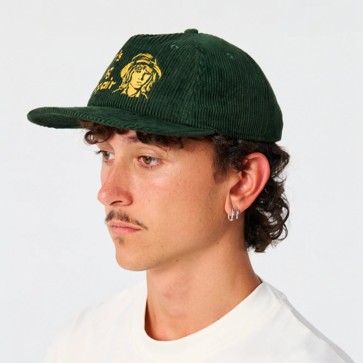 Person wearing a green cap with a logo on a white background