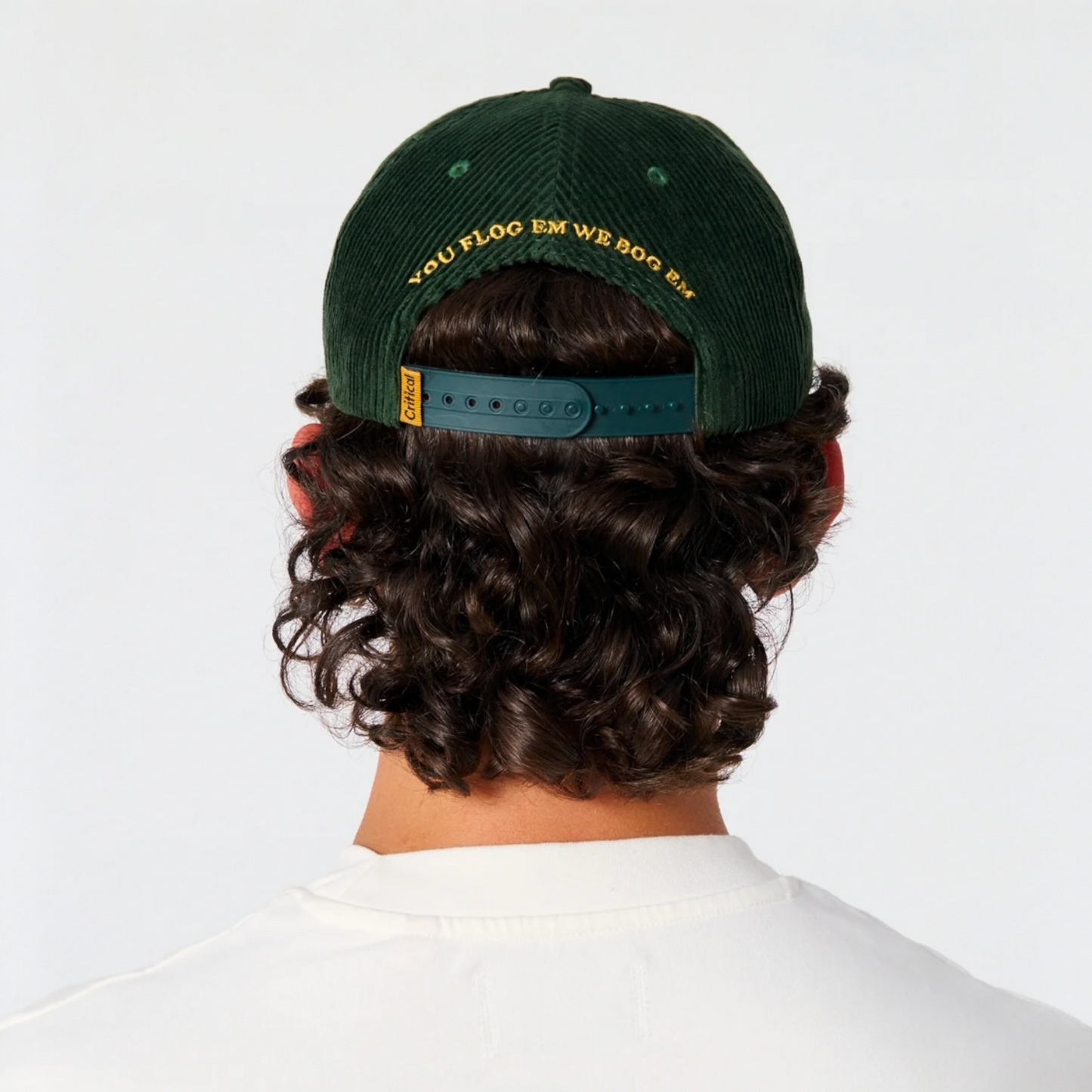 Green cap with text worn by a person on a white background