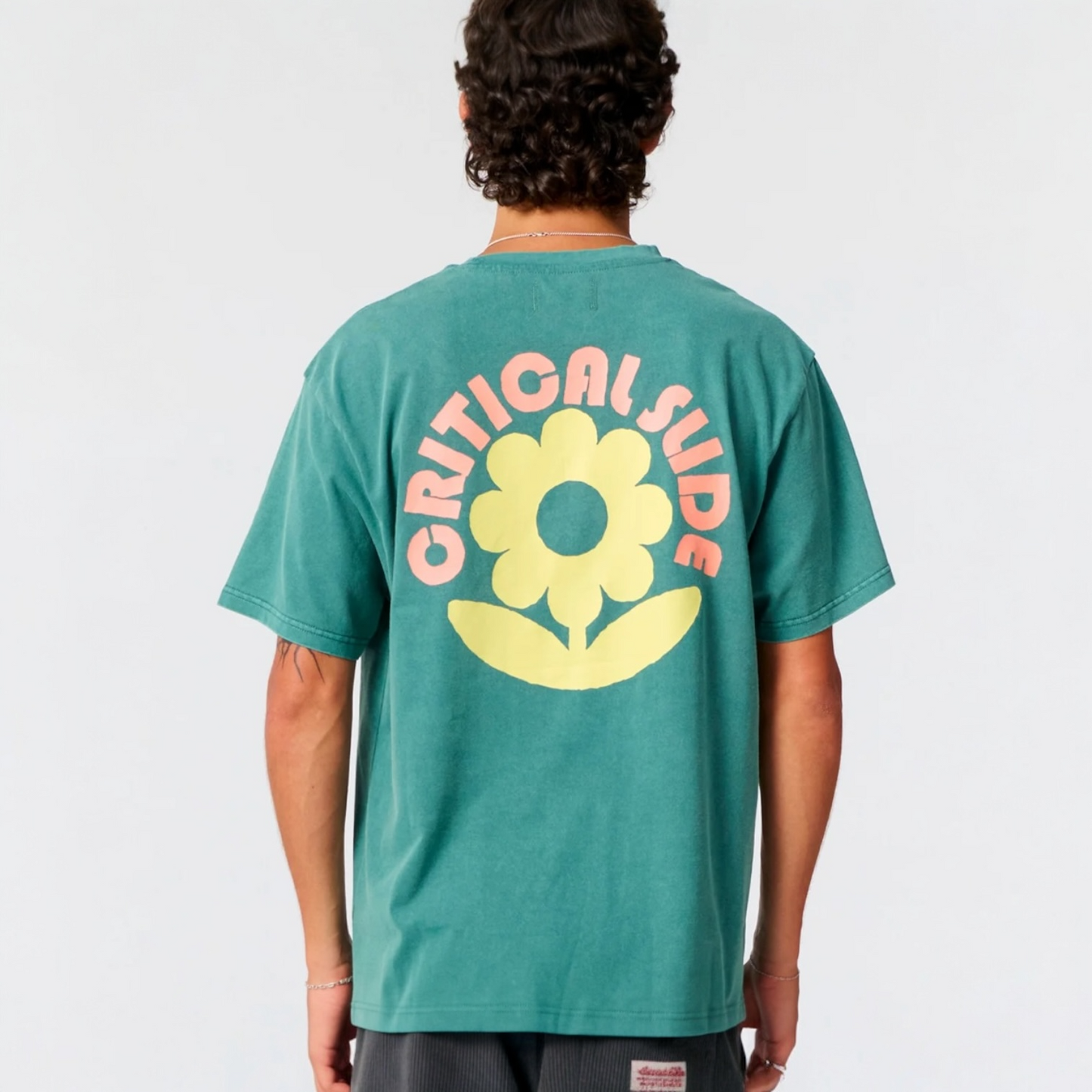 Person wearing a green t-shirt with 'Critical Slide Society' logo on the back