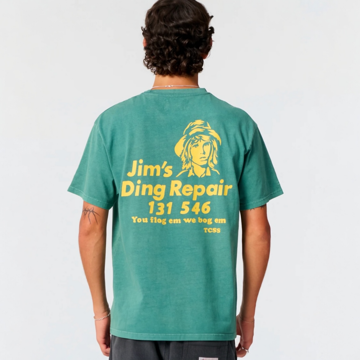 Person wearing a green t-shirt with yellow text and logo on the back