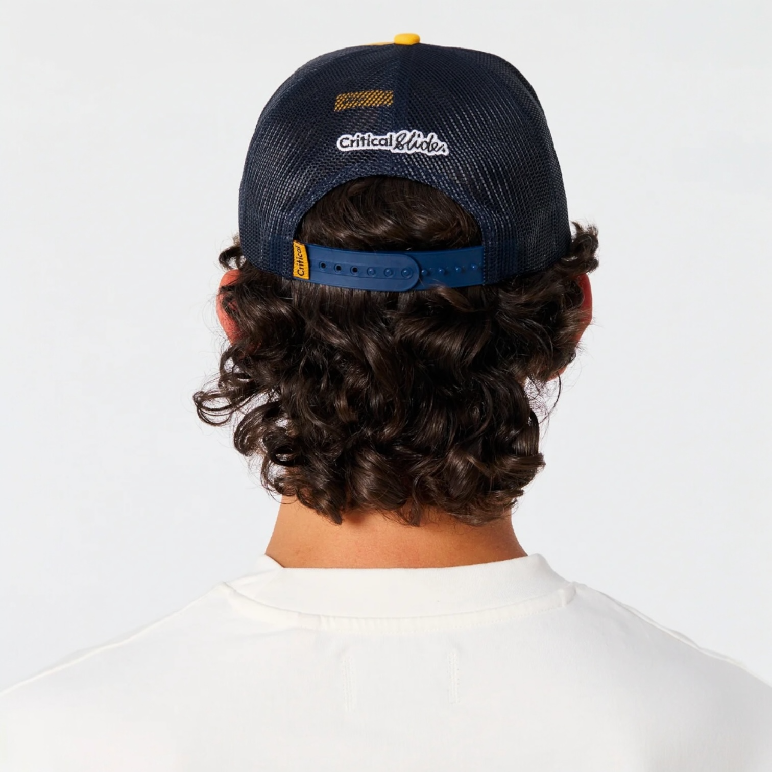 Person wearing a navy blue cap with 'Critical Hit' branding on a white background