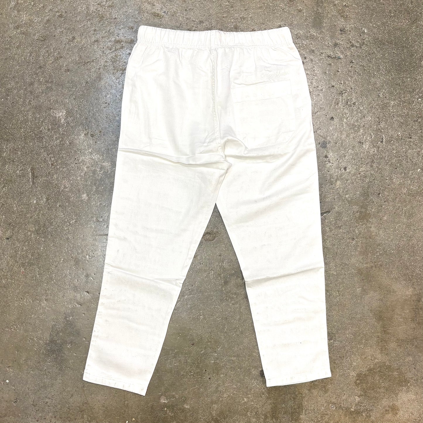 White pants on a textured gray surface