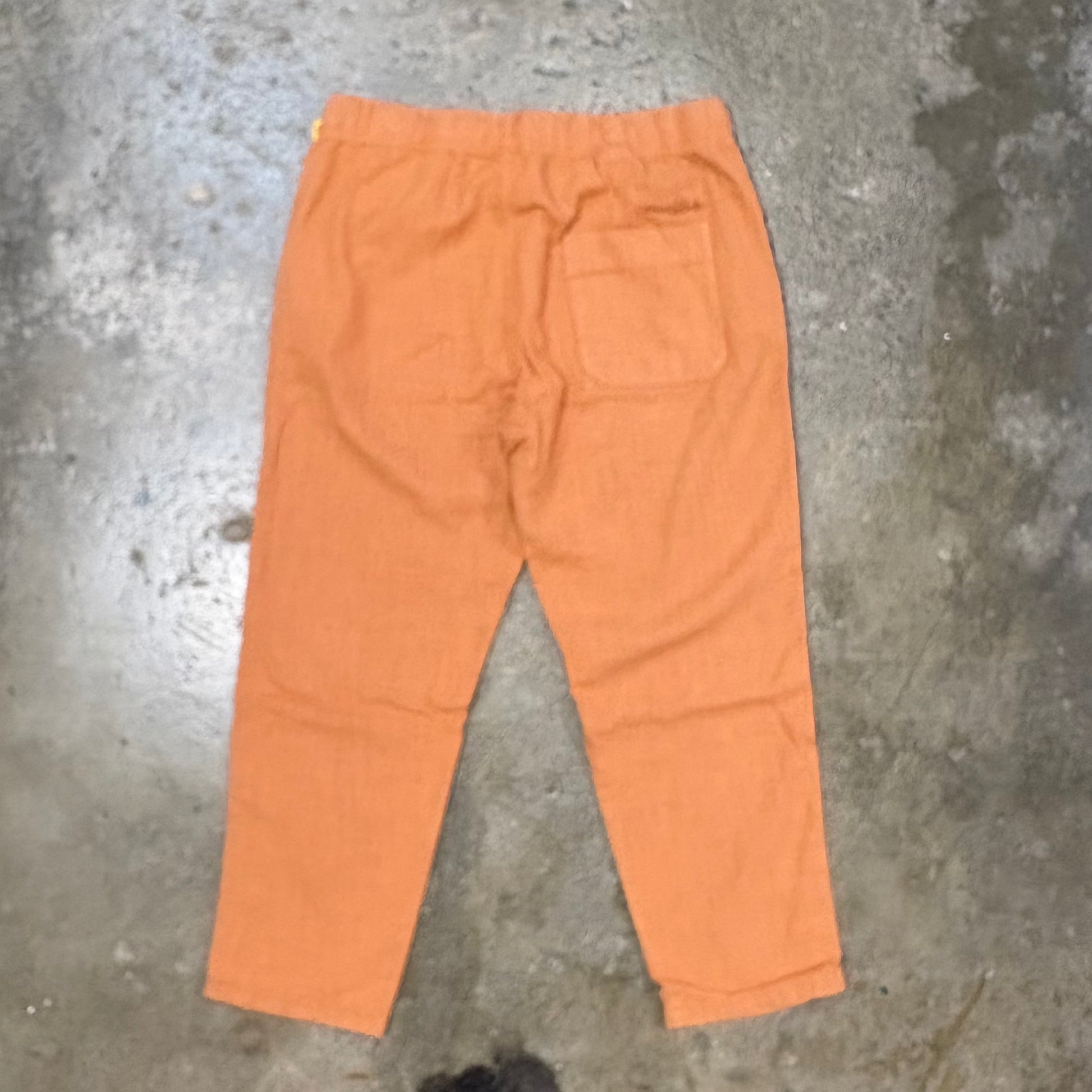 Orange pants on a textured gray surface