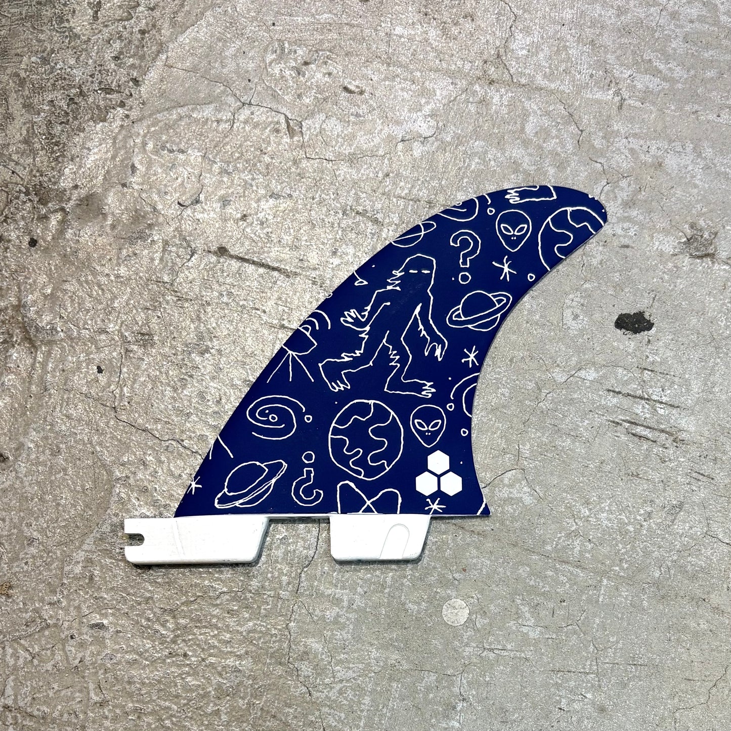 Blue surf fin with white patterns on a concrete surface