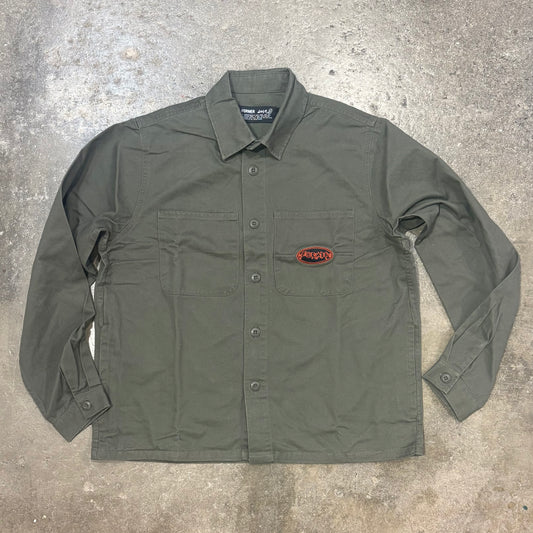 Green shirt with a logo on a gray concrete surface