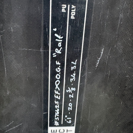 A close-up of a black textured surface with a vertical white label containing handwritten text and the partial brand name ECT.