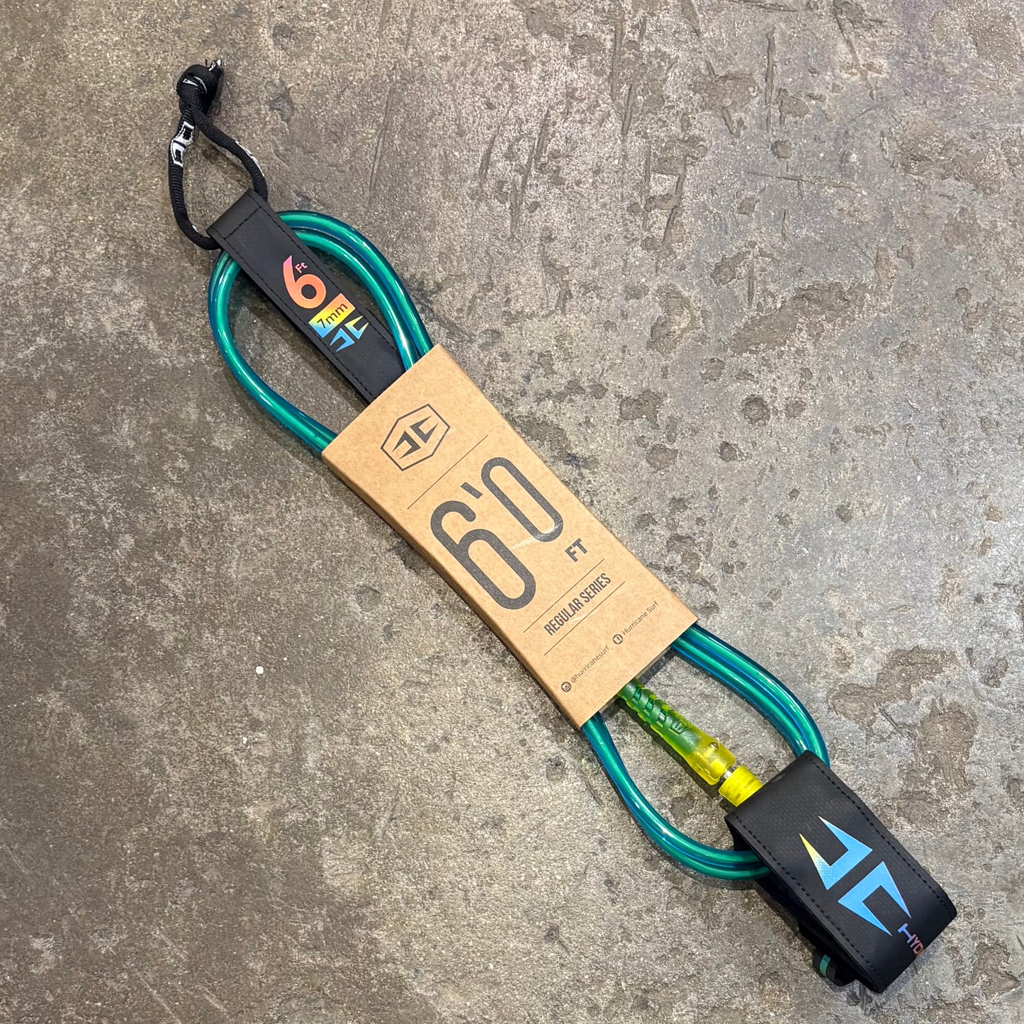 Surfboard leash with brand label on a concrete surface