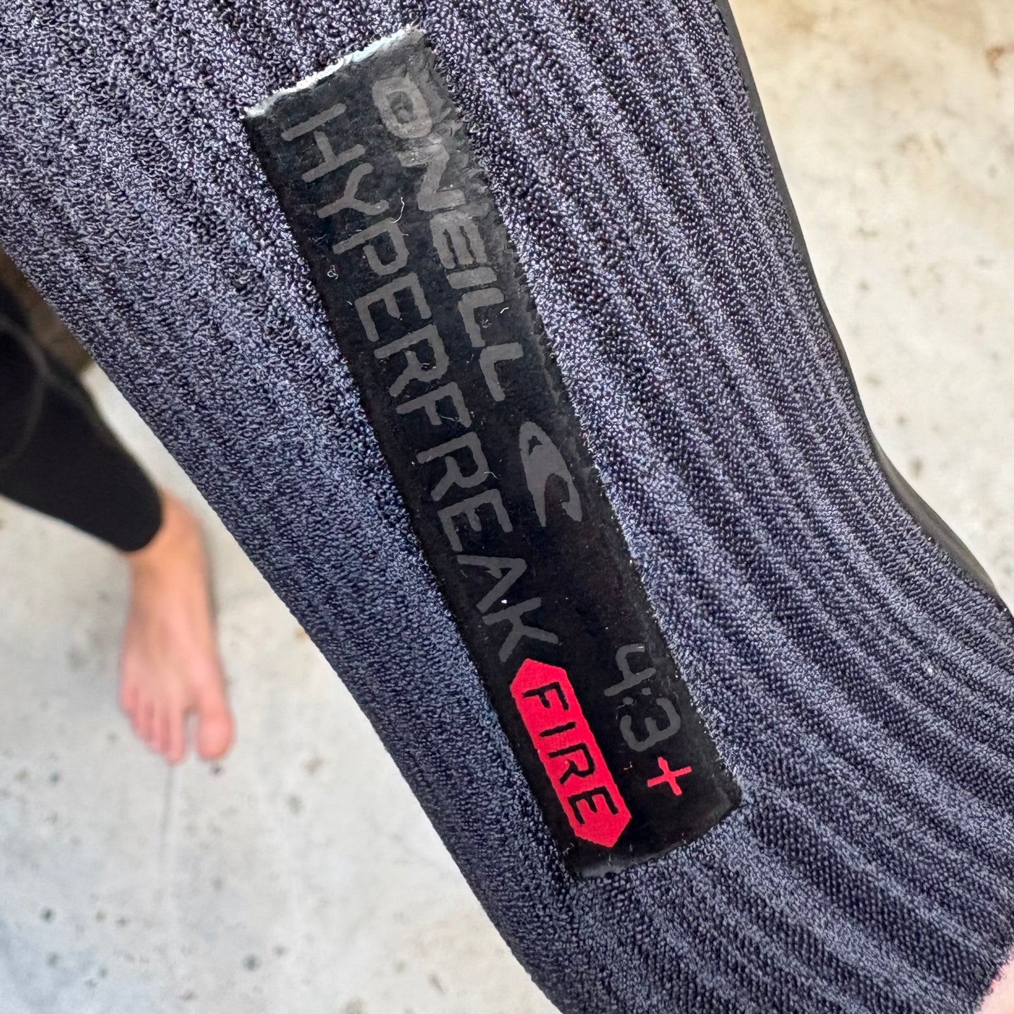Graymaterial  with O'Neill Hyperfreak Fire label on a concrete floor