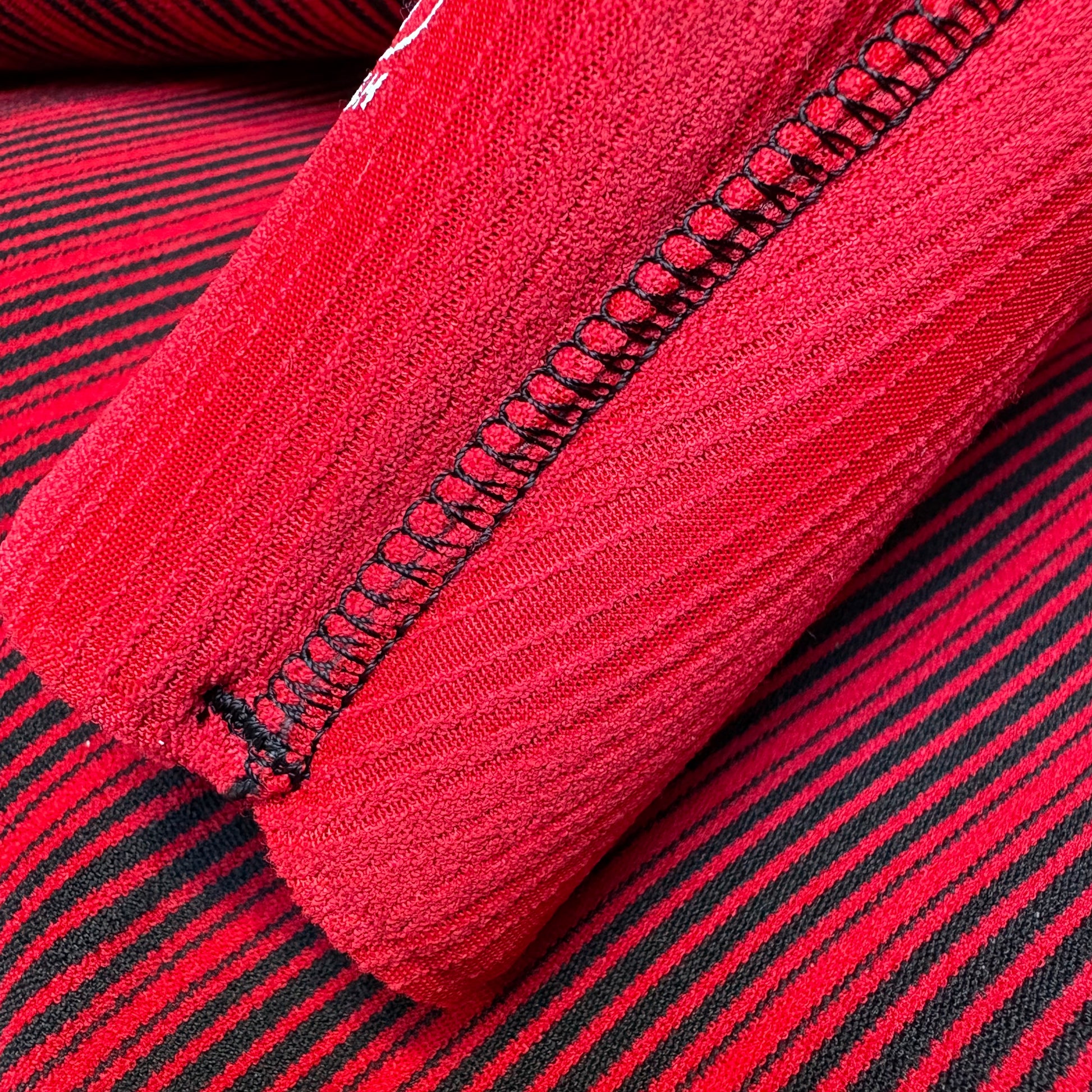 Close-up of a red fabric with black stitching detail