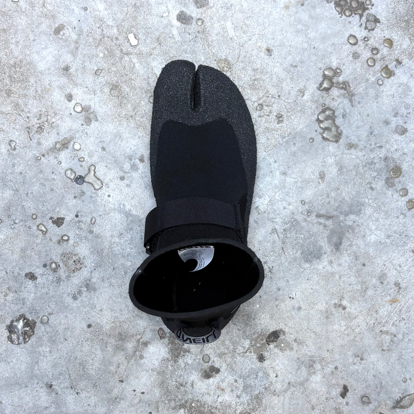 Black split-foot wetsuit on a textured gray surface