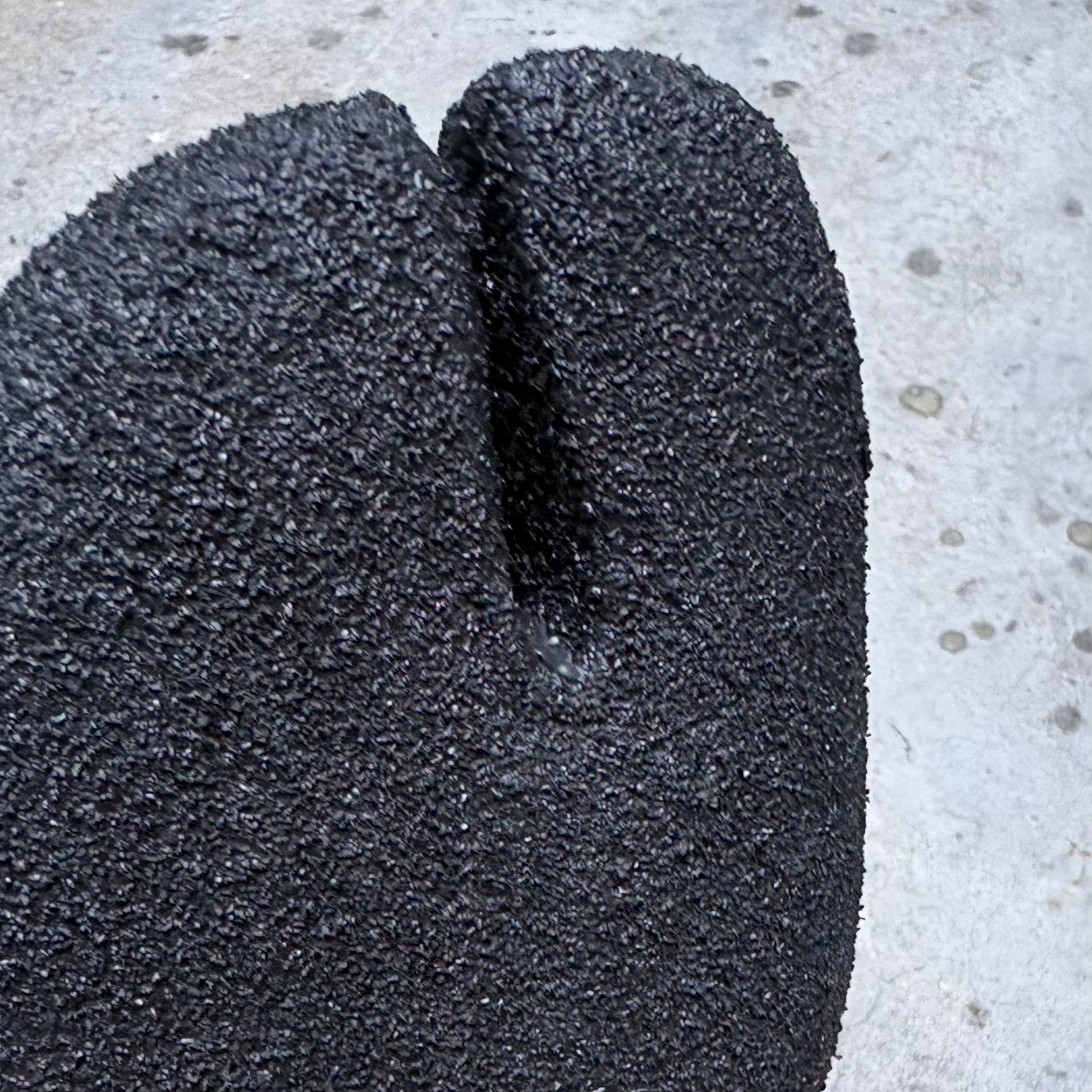 Close-up of a textured black shoe sole on a concrete surface