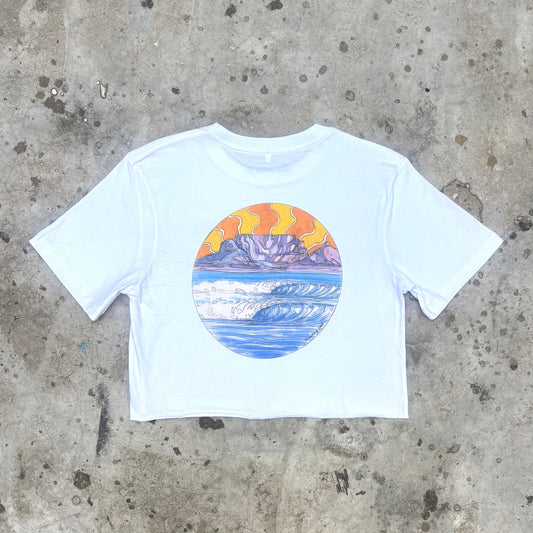 White crop top with a colorful graphic of Table Mountain and ocean on a concrete surface
