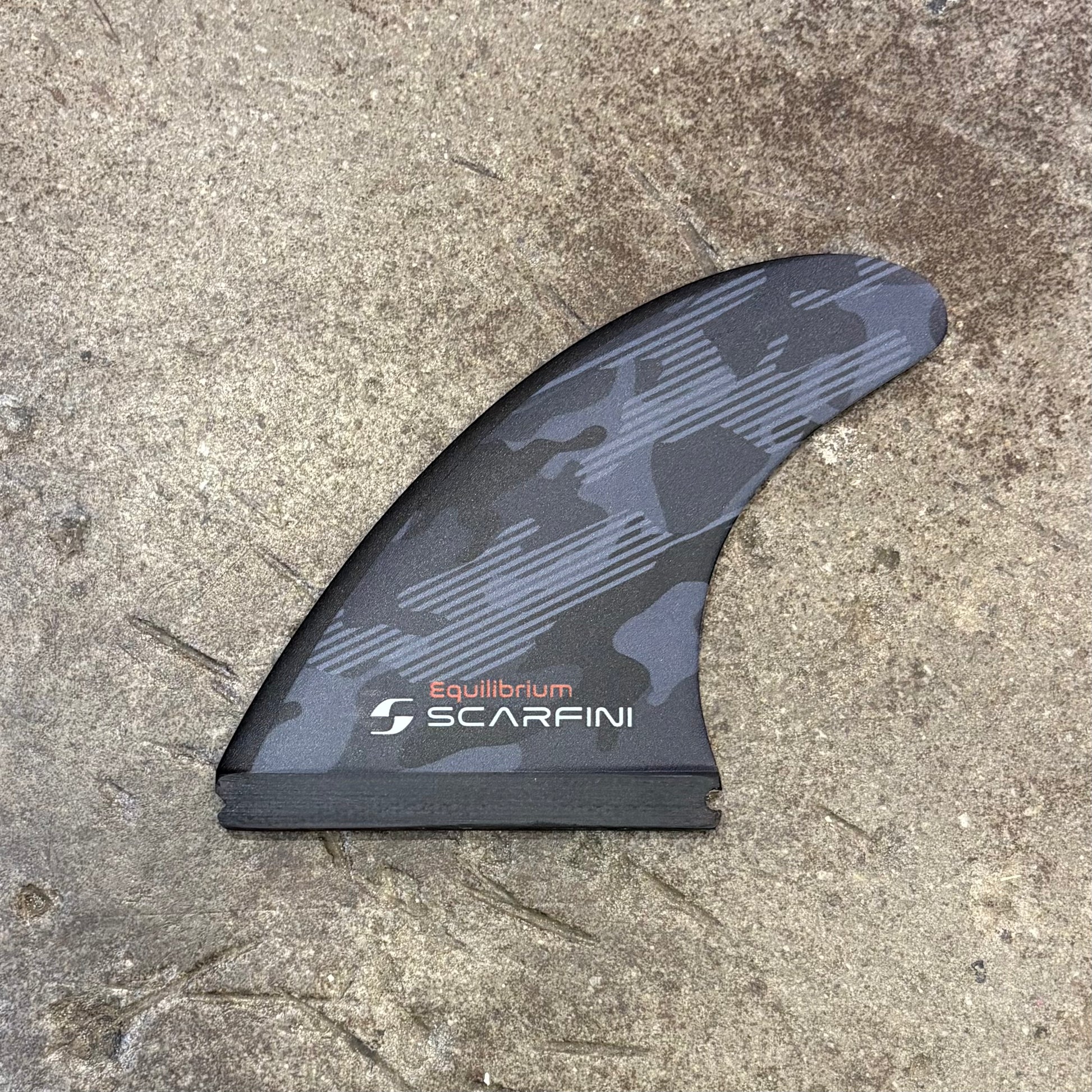 Black and gray fin with 'Equilibrium Scarfini' branding on a concrete surface