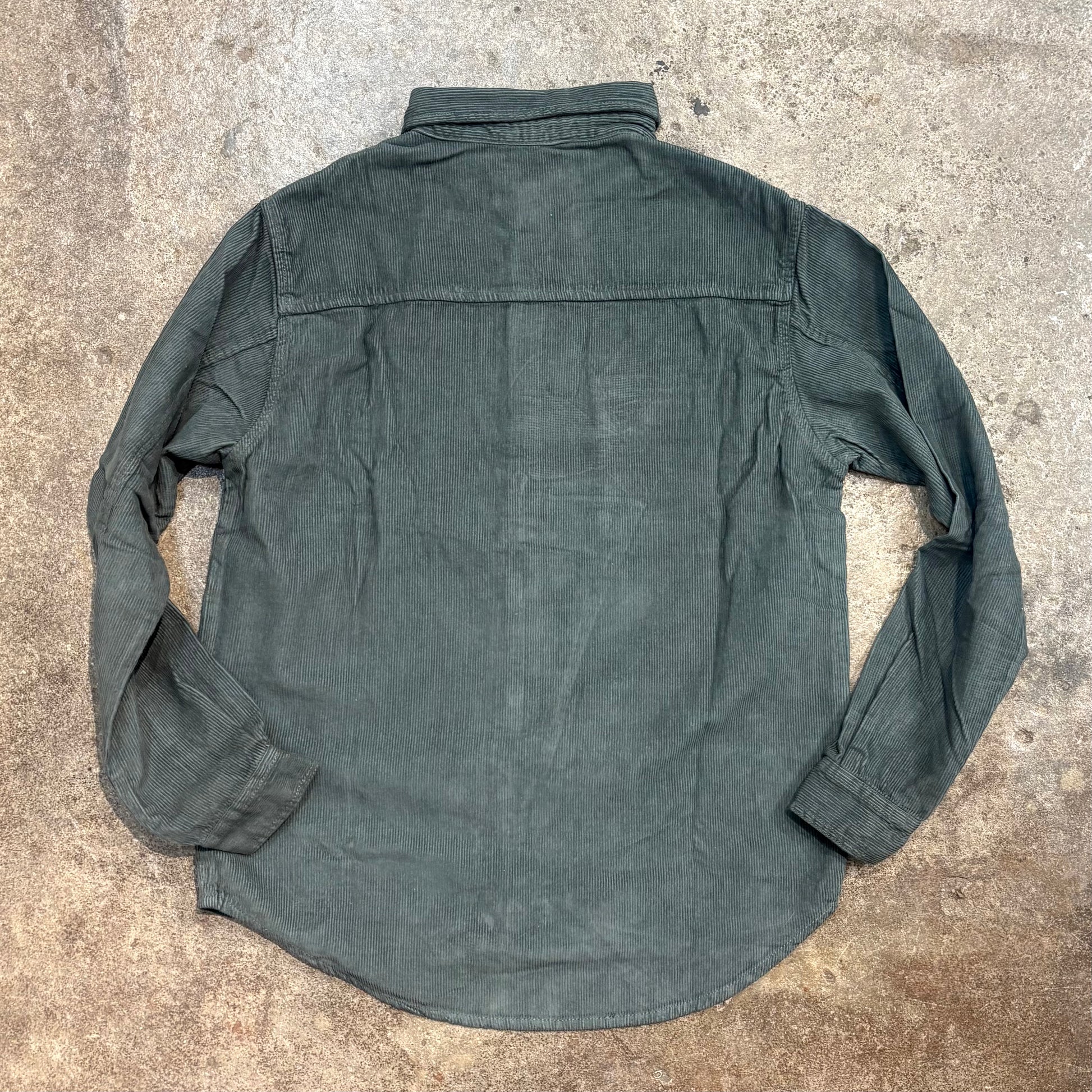 Green shirt on a textured concrete surface