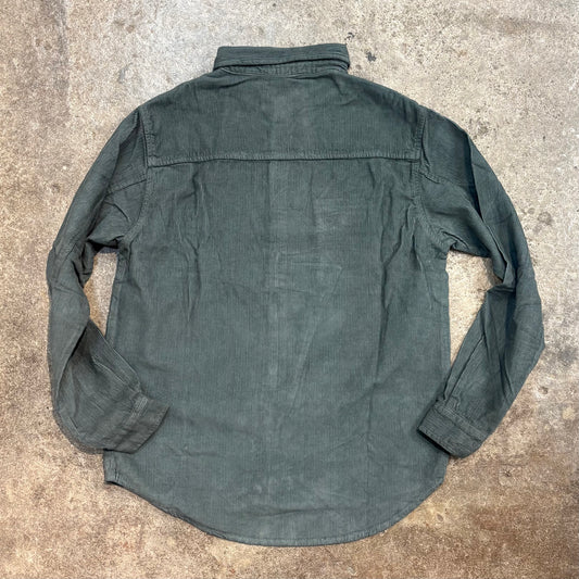 Green shirt on a textured concrete surface