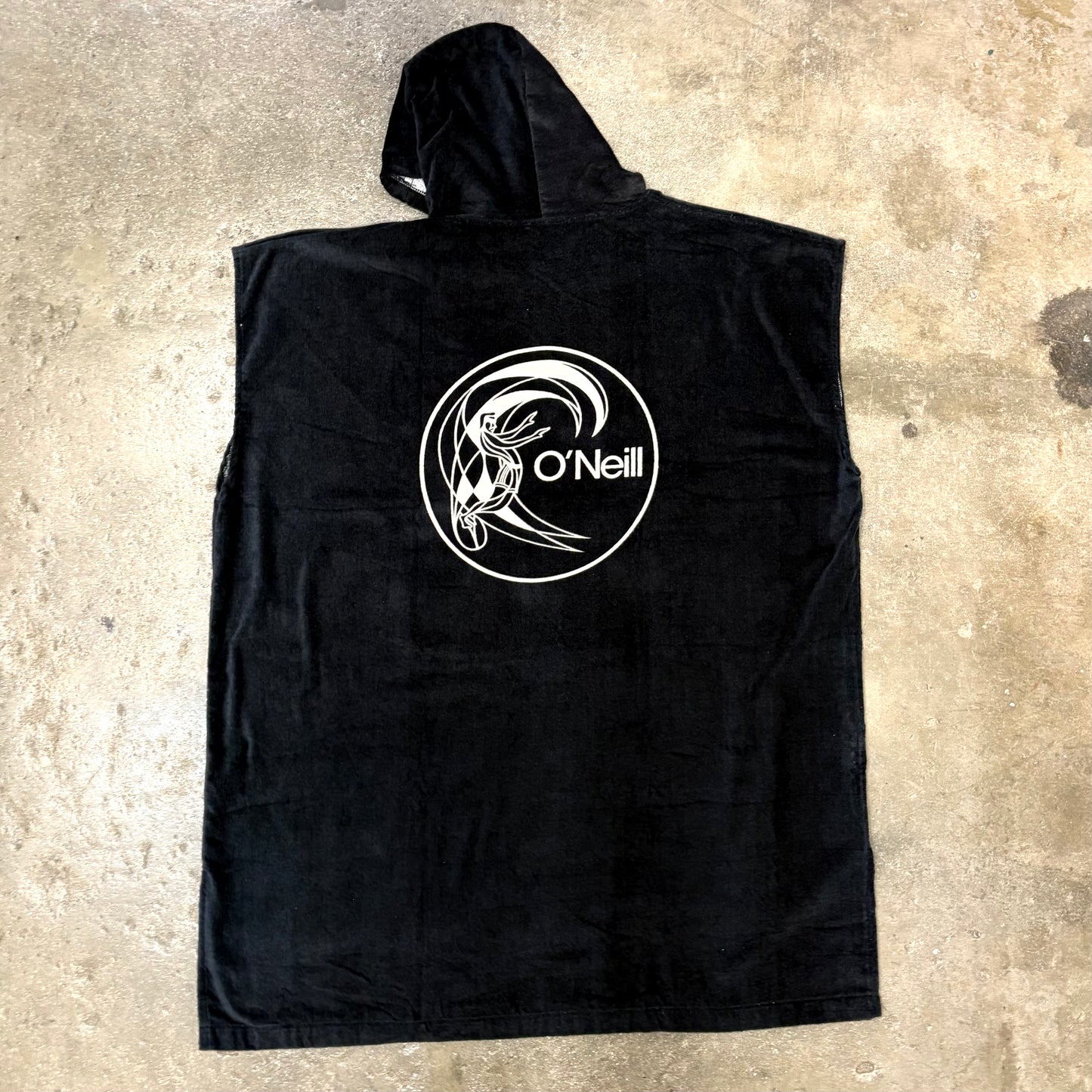 Black sleeveless hoodie with a white logo on a concrete surface