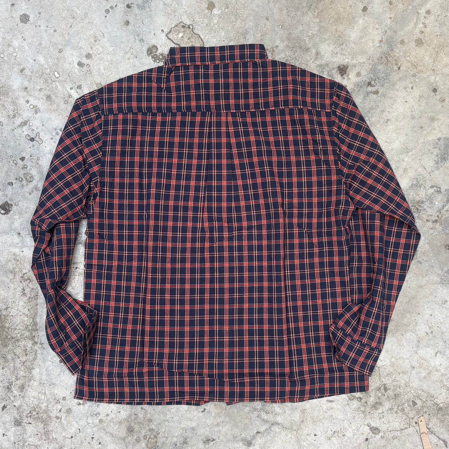 Red and blue plaid shirt on a concrete surface