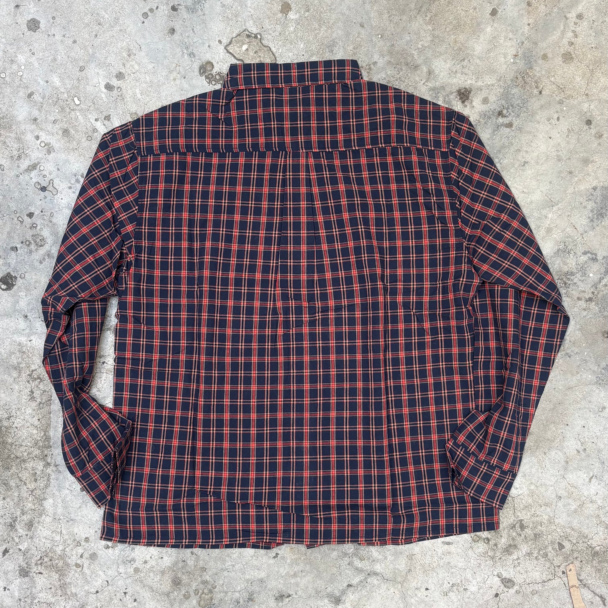 Red and blue plaid shirt on a concrete surface