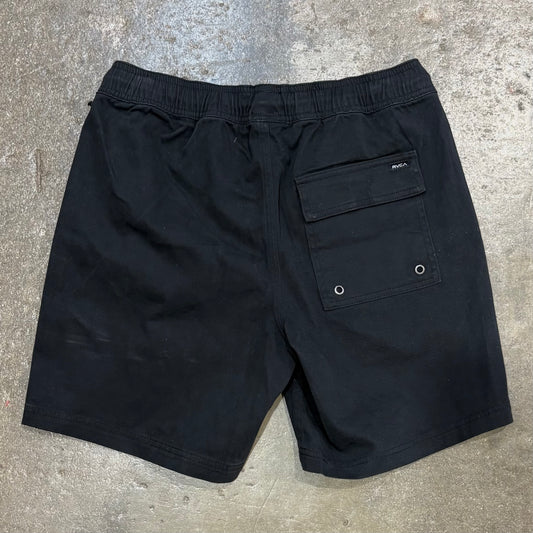 Black shorts with a pocket on a concrete surface