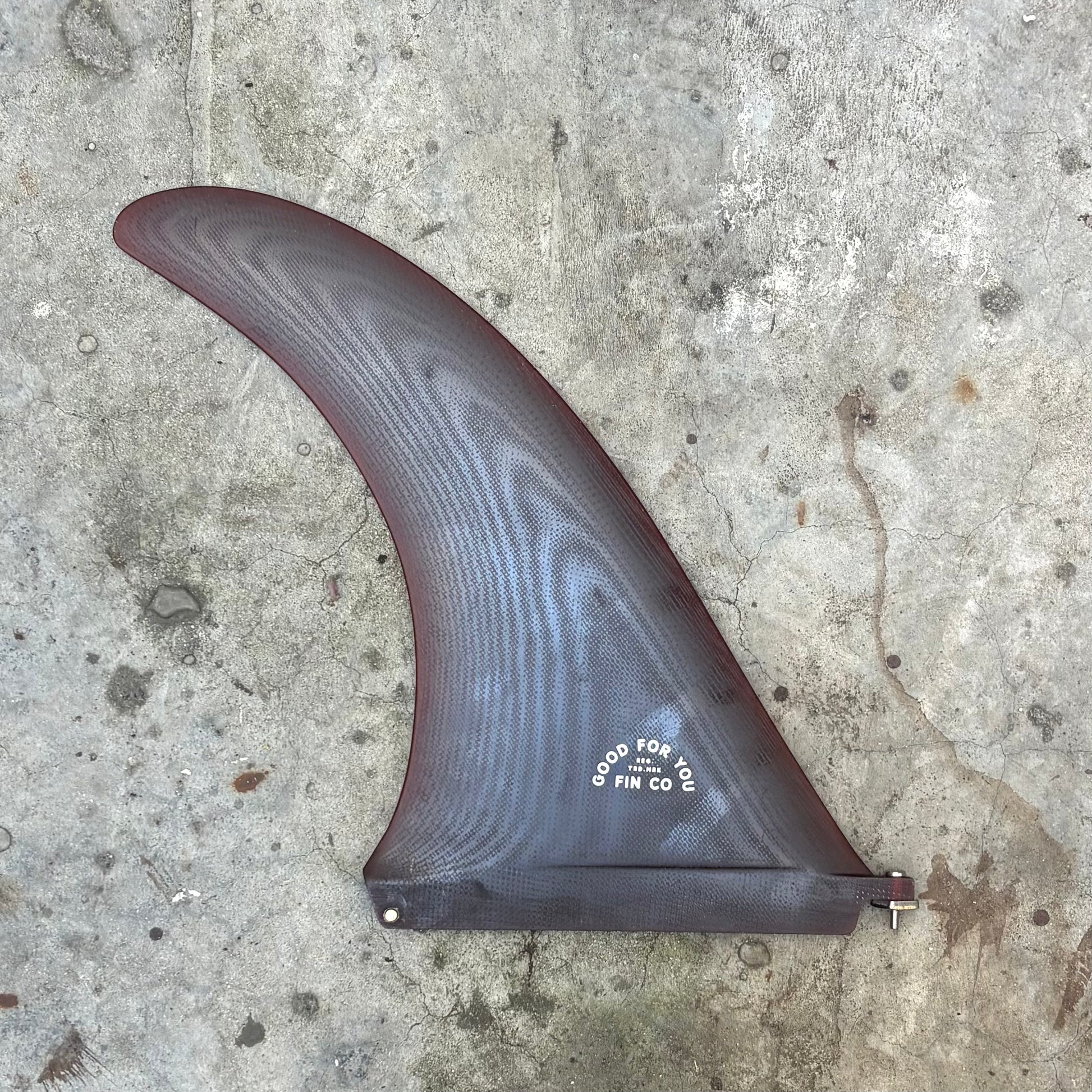 Surfboard fin on a concrete surface