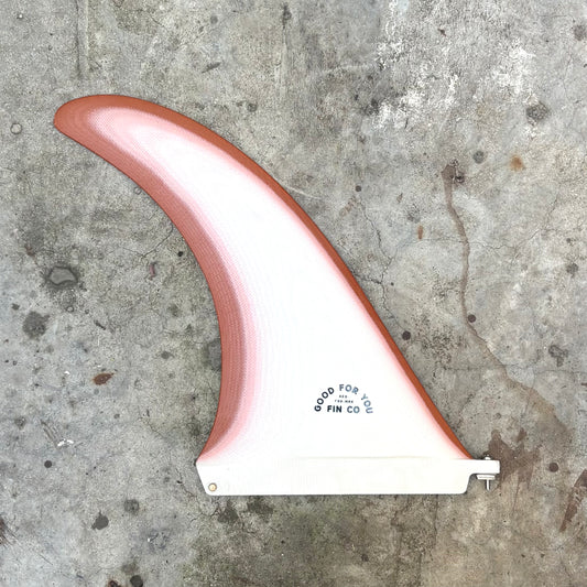 Surfboard fin with gradient design on a concrete surface