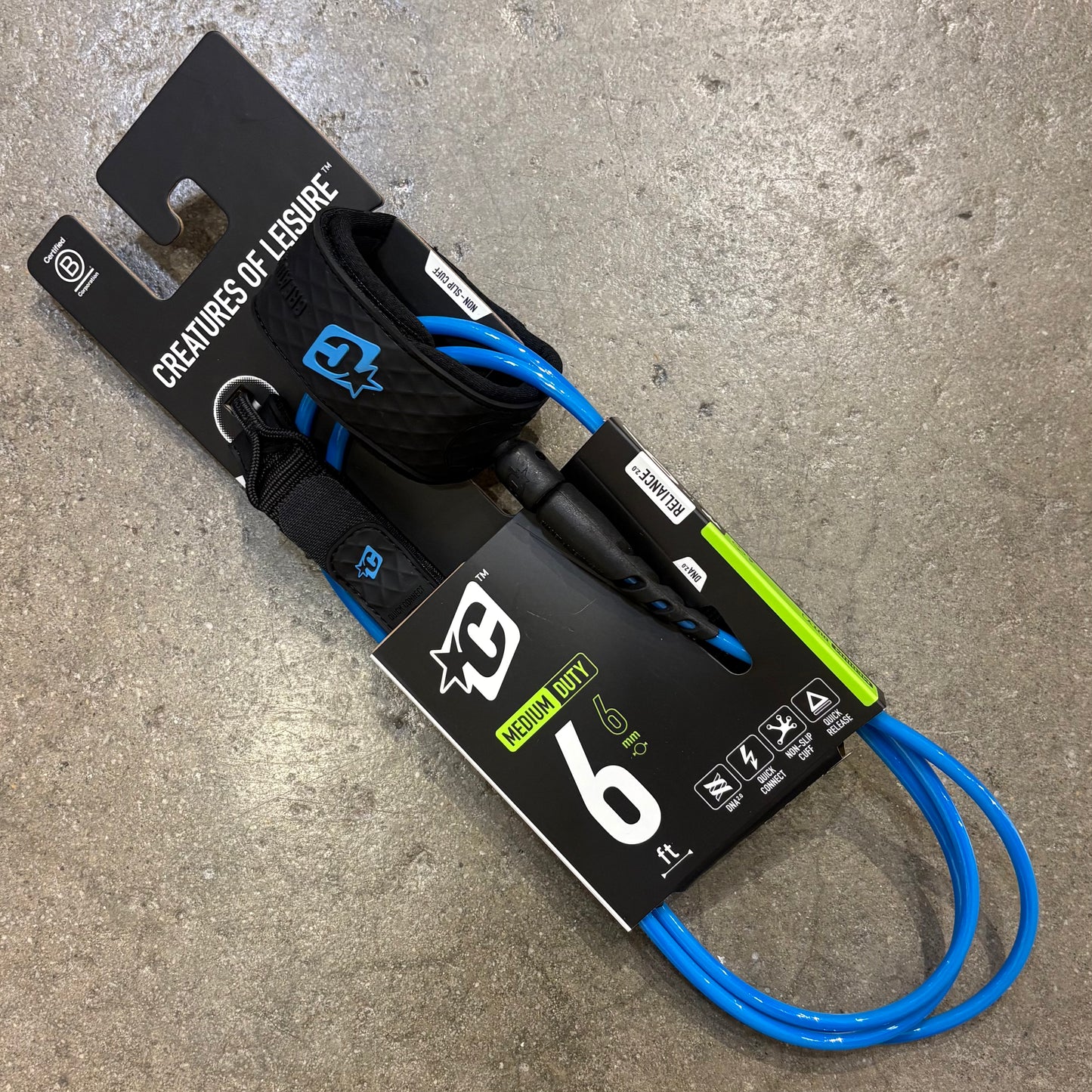 Leash with blue cord on a gray surface, featuring 'Creatures of Leisure' branding.