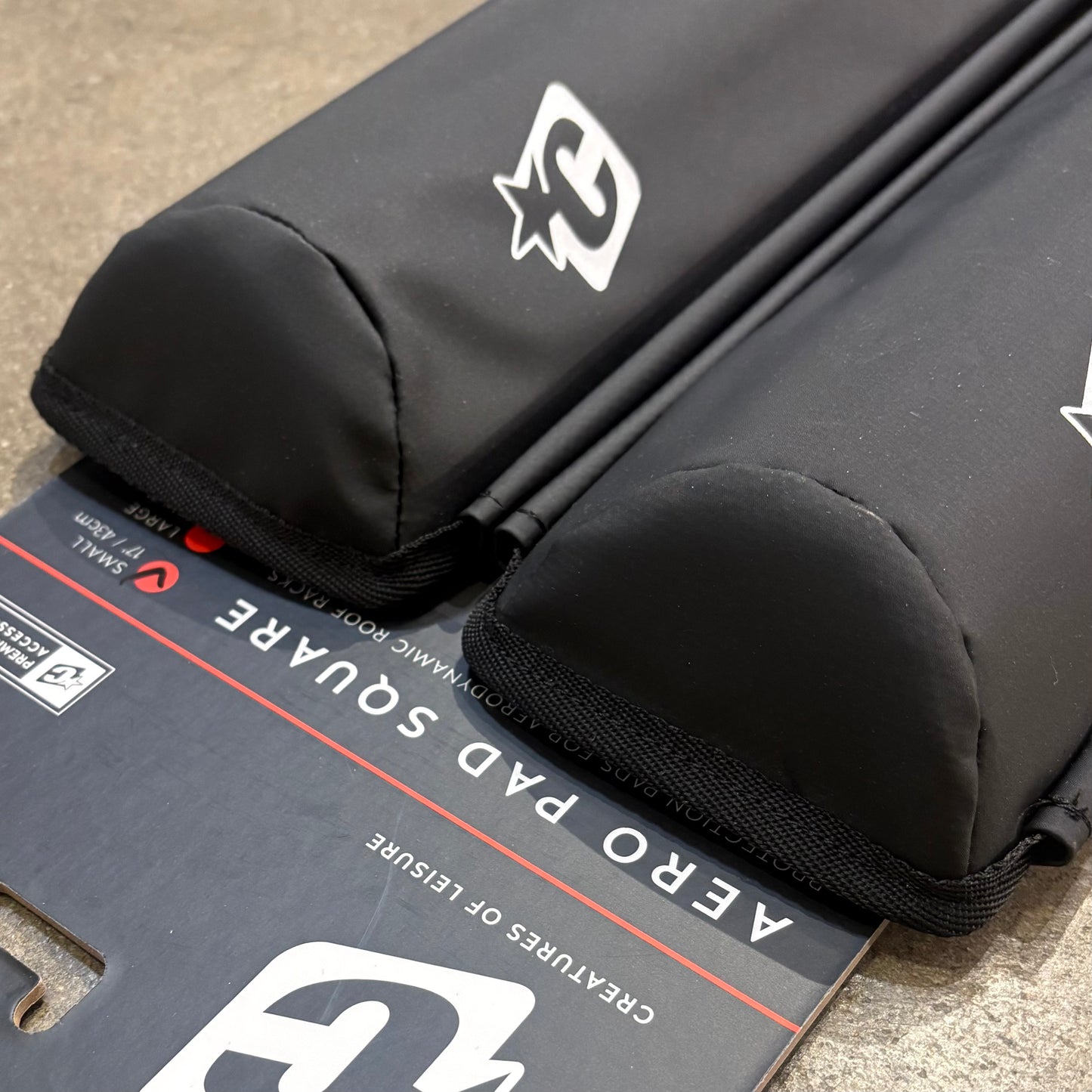 Black protective pad with a brand logo on a cardboard box labeled 'Aero Pad Square'.