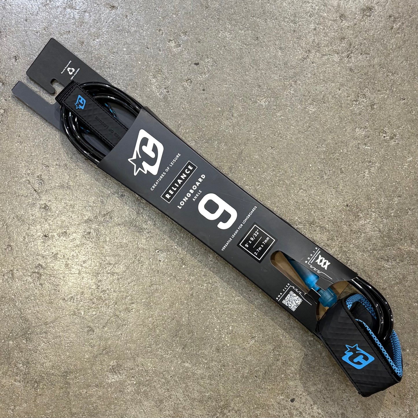 Surfboard leash with brand logo on a concrete surface