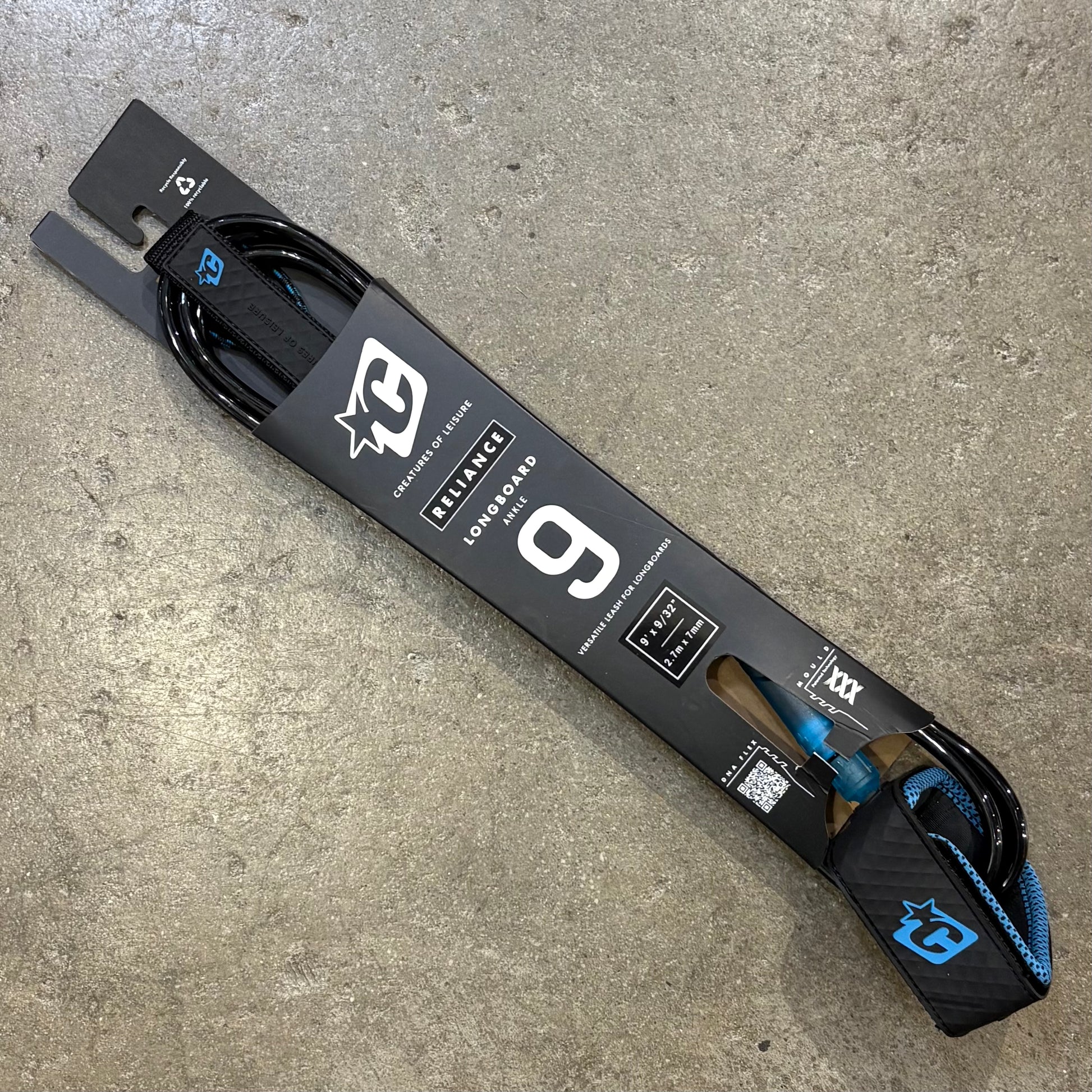 Surfboard leash with brand logo on a concrete surface
