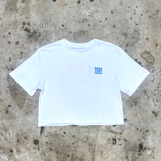 White crop top with blue text on a concrete surface