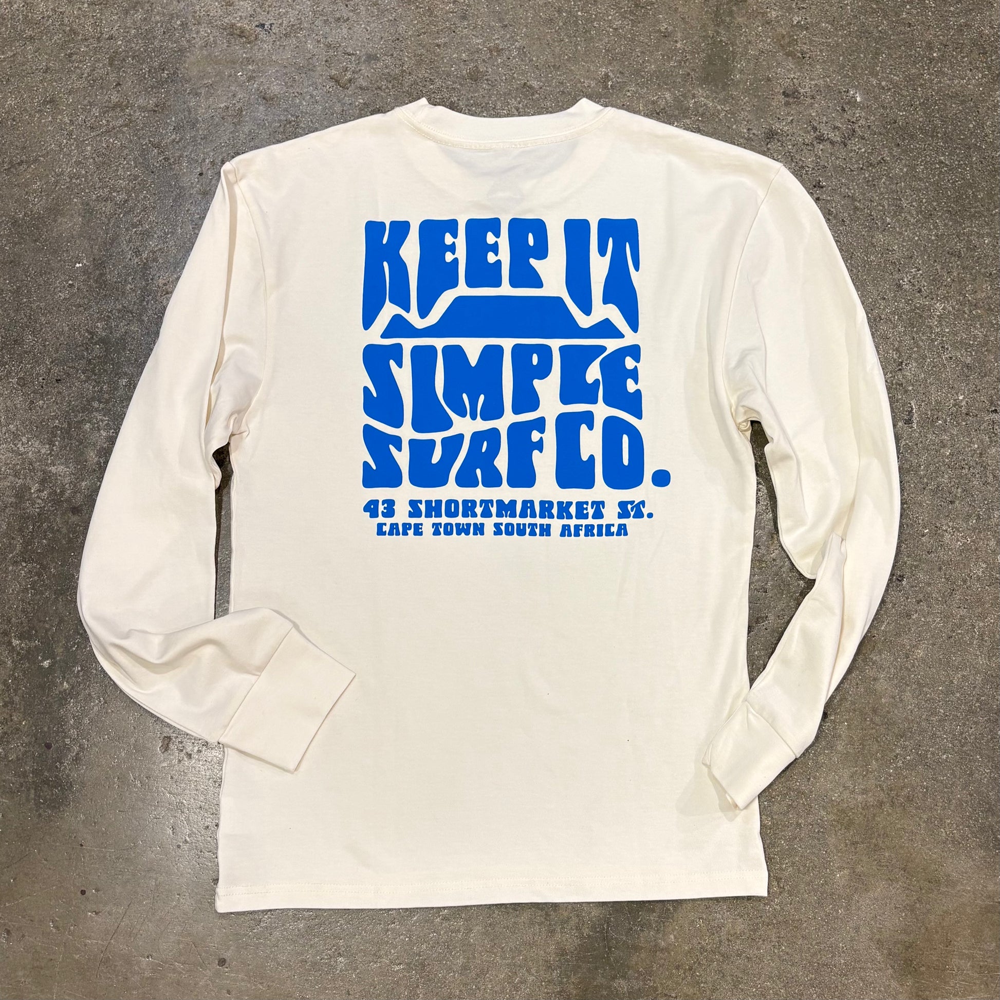 White long-sleeve shirt with blue text on a textured gray background