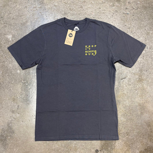 Dark gray Kiss t-shirt with yellow text on a concrete surface