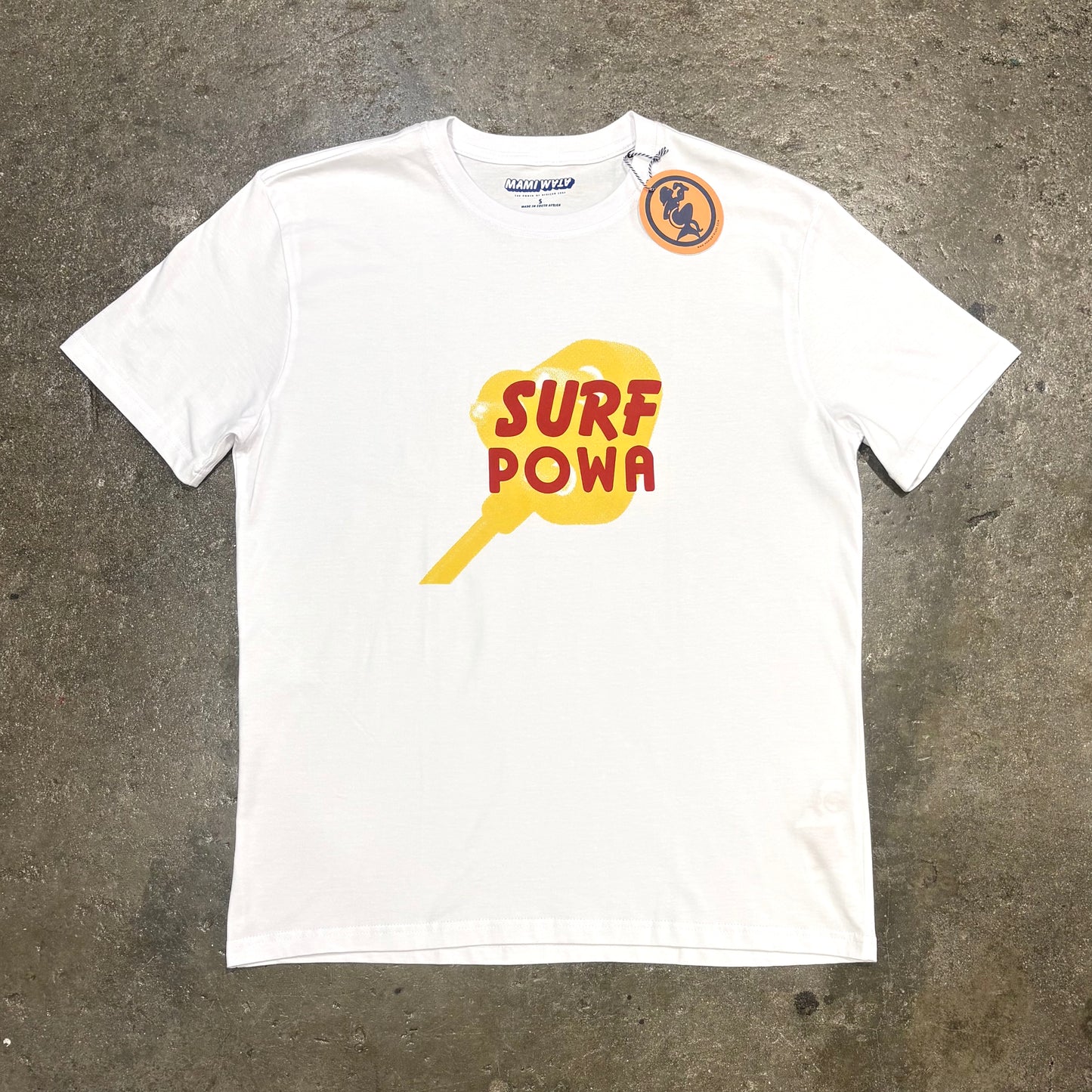 White t-shirt with 'Surf Powa' design on a concrete surface