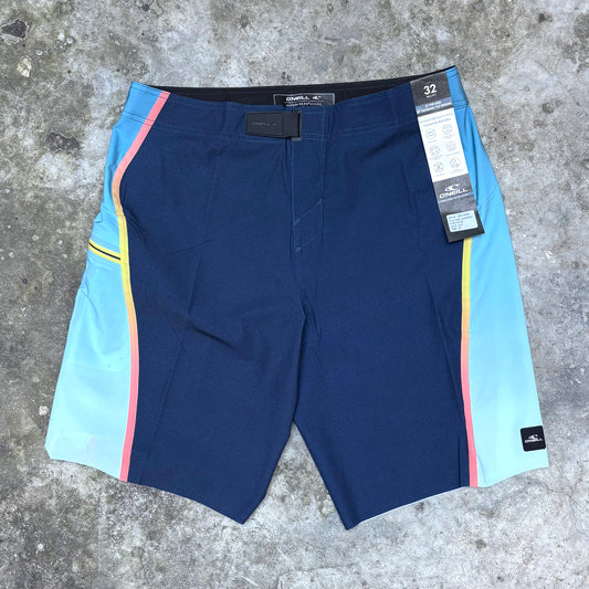 Blue shorts with colorful side panels on a concrete surface