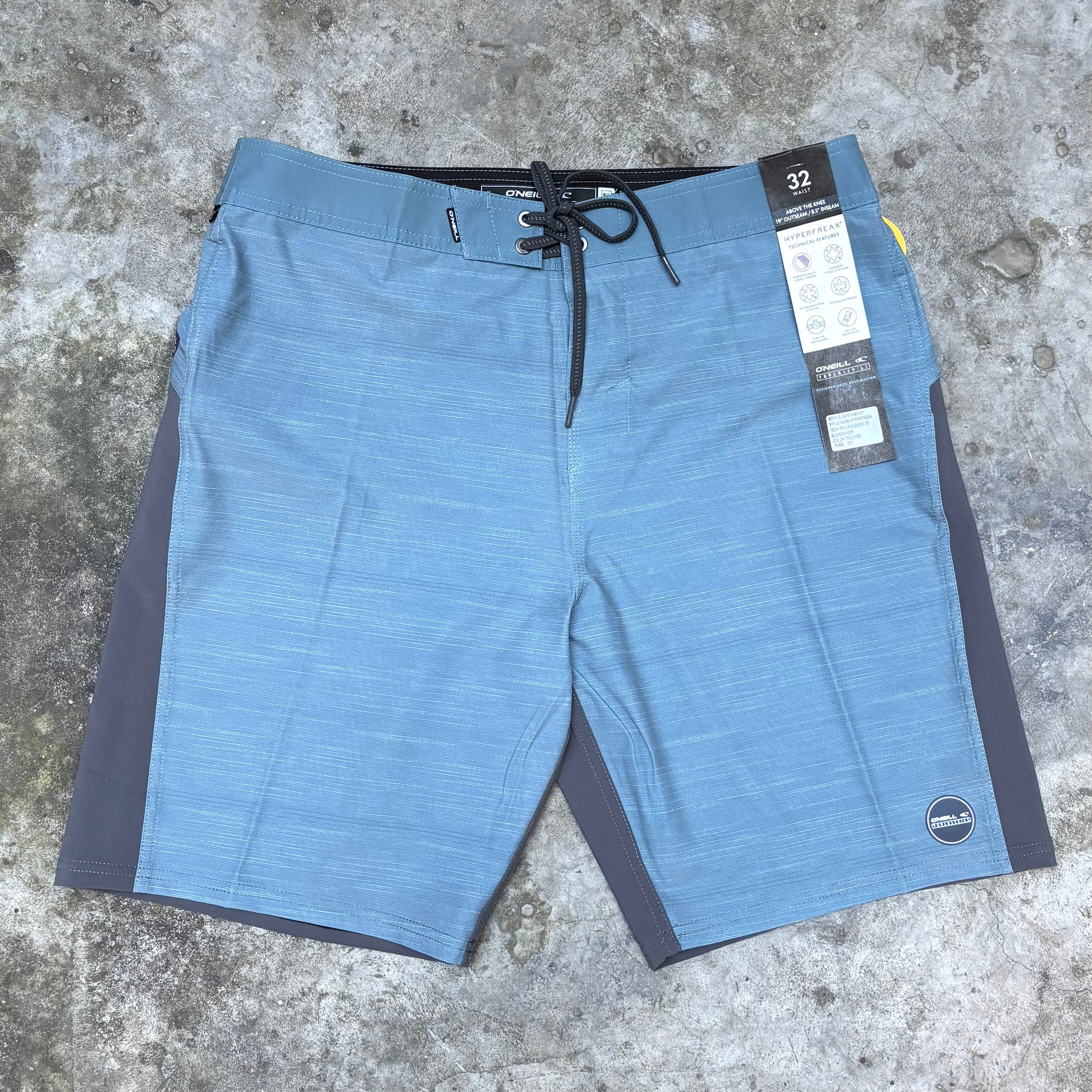 Blue shorts with a brand tag on a concrete surface