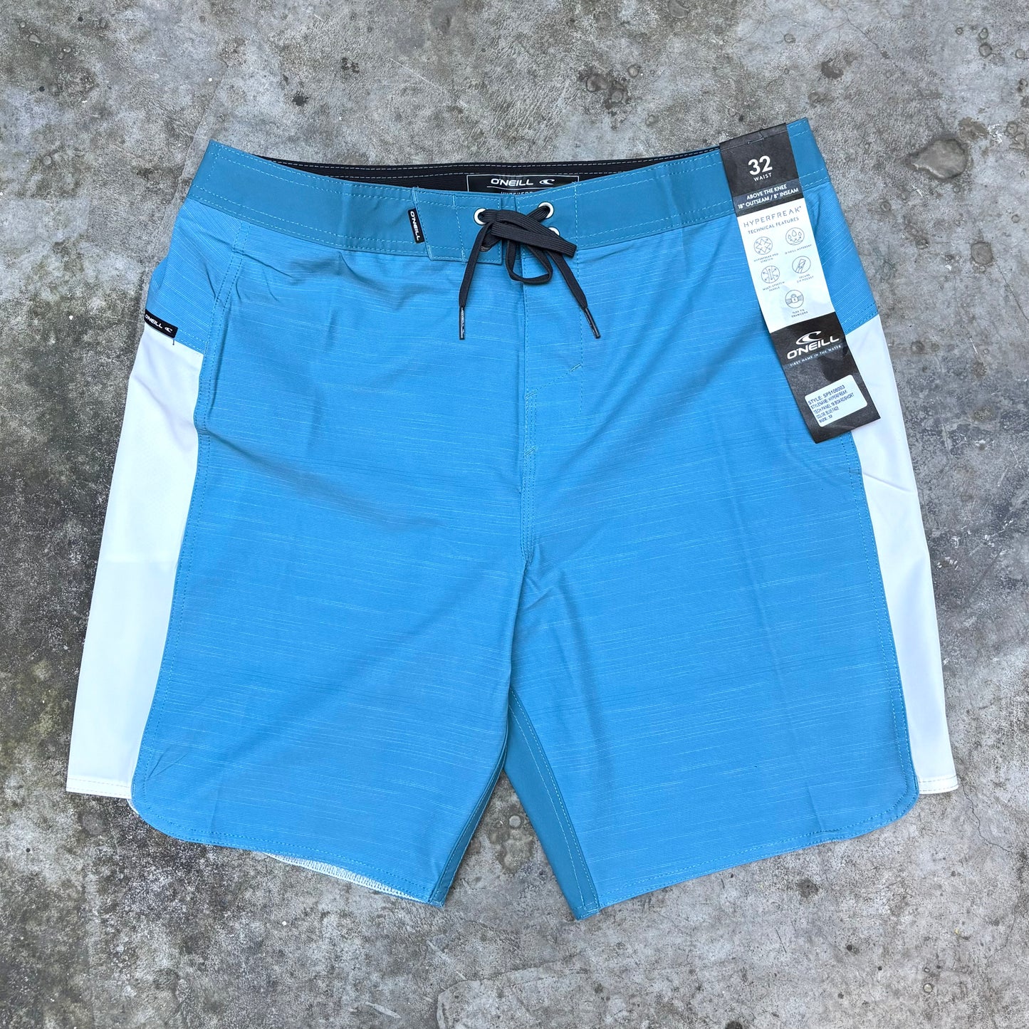 Blue shorts with a white stripe on a concrete surface
