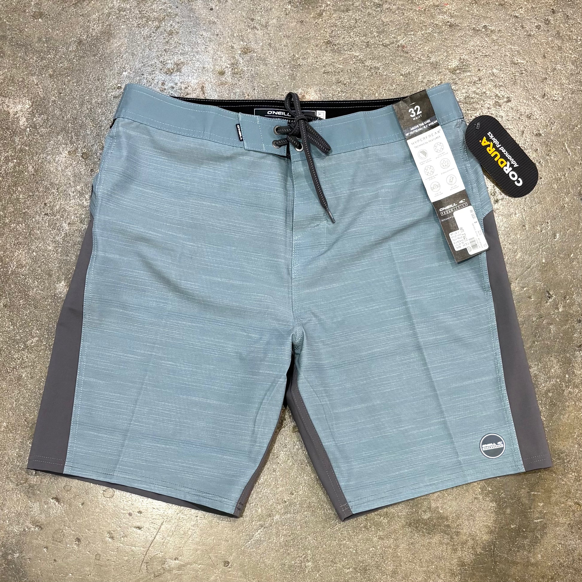 O'NEILL TECH TRVLR ENDURO 20" BOARDSHORTS ON CONCRETE SURFACE