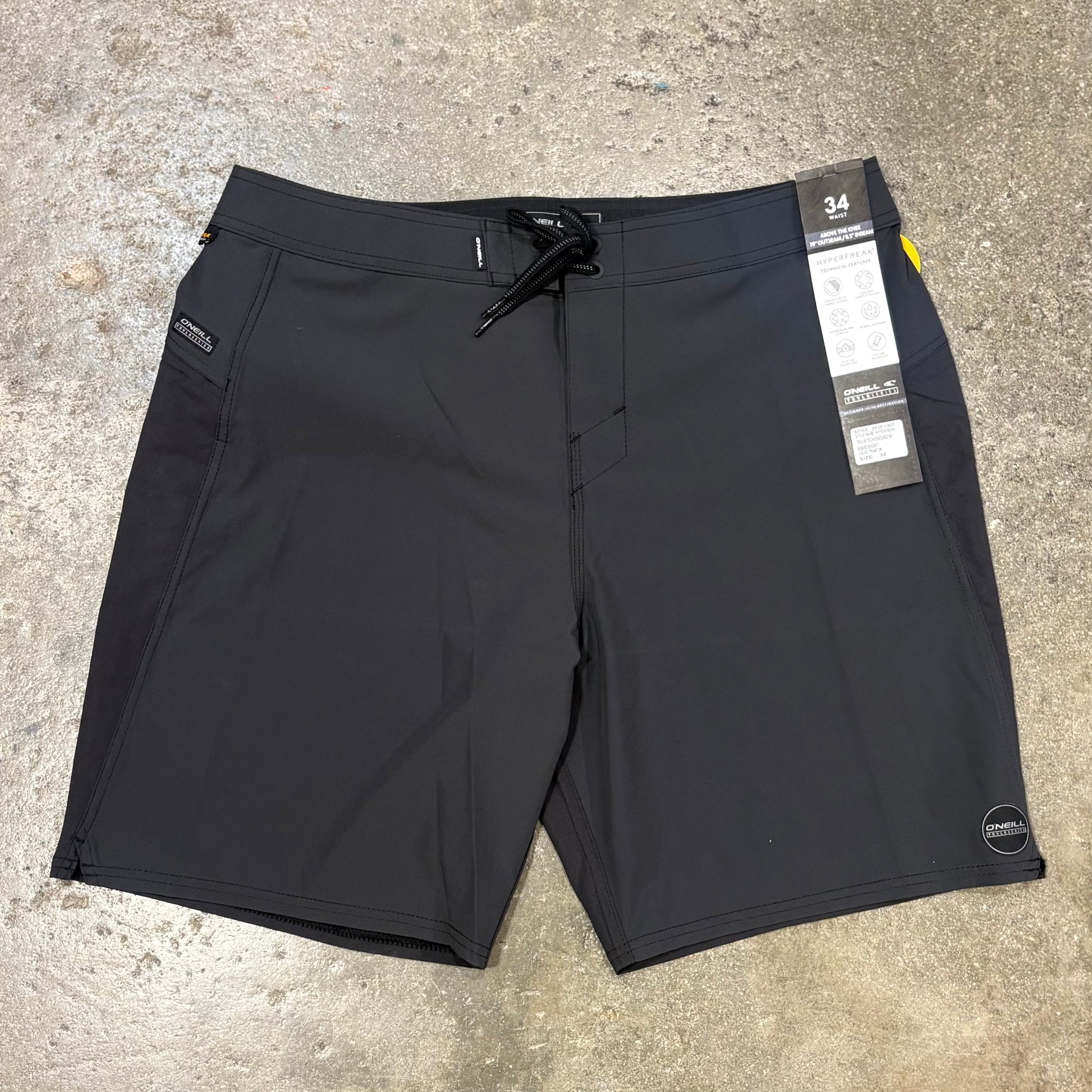 Black shorts with a tag on a concrete surface
